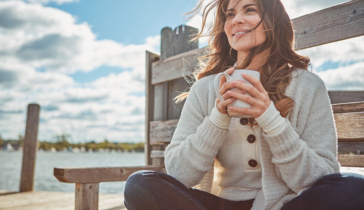 Confident woman smiling outdoors after a smile makeover, highlighting orthodontic treatments for adults and family orthodontic care benefits.