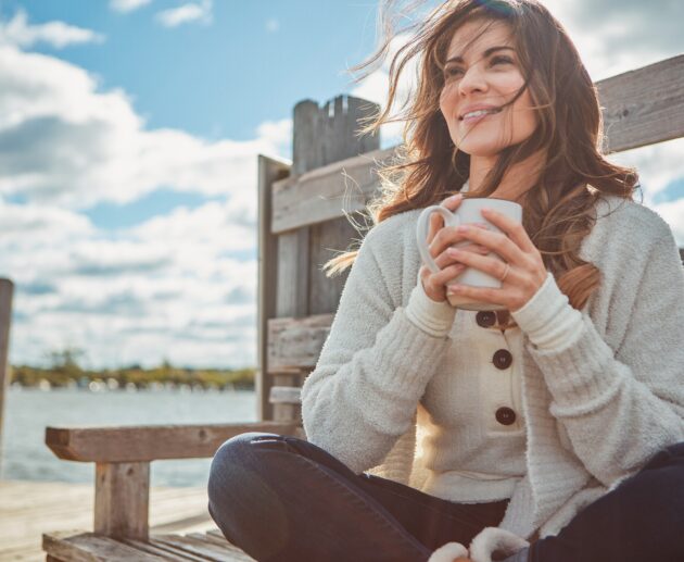 Confident woman smiling outdoors after a smile makeover, highlighting orthodontic treatments for adults and family orthodontic care benefits.