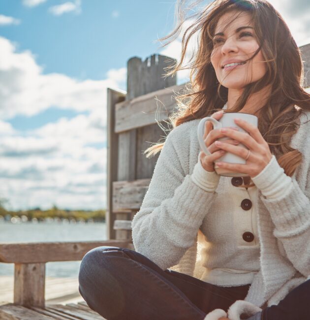 Confident woman smiling outdoors after a smile makeover, highlighting orthodontic treatments for adults and family orthodontic care benefits.
