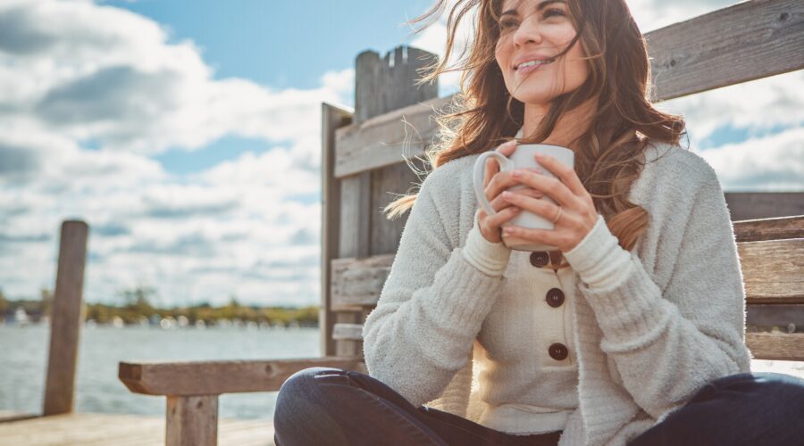 Confident woman smiling outdoors after a smile makeover, highlighting orthodontic treatments for adults and family orthodontic care benefits.