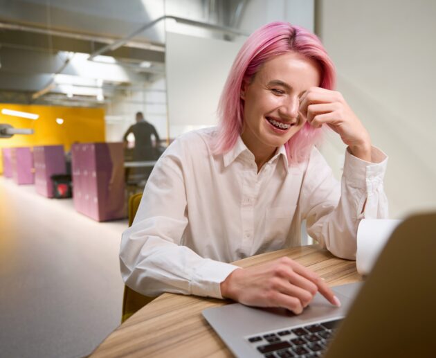 Confident professional woman smiling at work while considering adult braces, orthodontics for adults, and straightening teeth without braces.