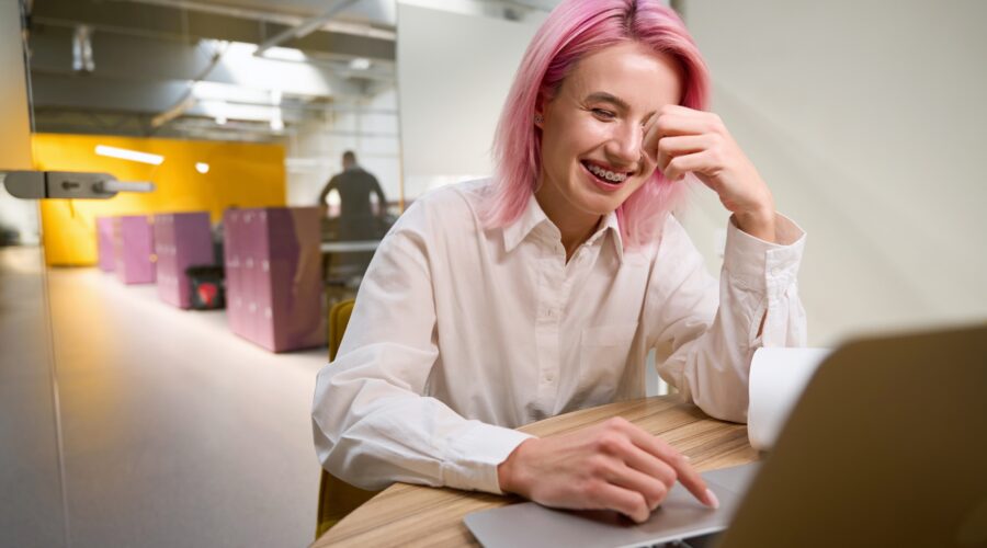 Confident professional woman smiling at work while considering adult braces, orthodontics for adults, and straightening teeth without braces.