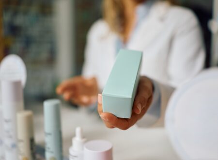 Woman comparing active skincare products, retinal cream, and acne prone skincare products while deciding whether expensive skincare is worth the price.