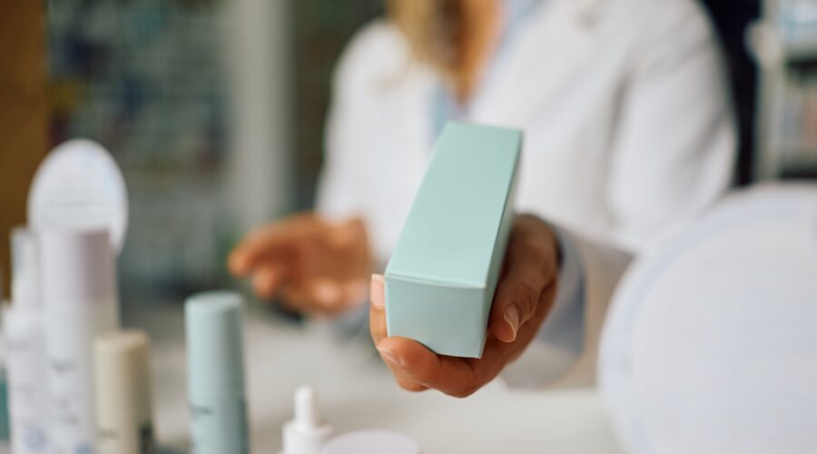 Woman comparing active skincare products, retinal cream, and acne prone skincare products while deciding whether expensive skincare is worth the price.