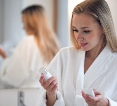 Skincare products featuring active skincare products, retinal night cream, and morning vitamin C serum arranged as part of a simple routine.