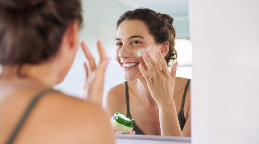 Woman applying an anti ageing serum after using a sensitive skin cleanser as part of a simple active skincare routine.