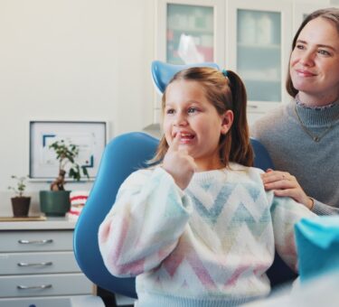 Parent speaking with a childrens orthodontist about family orthodontic care and early orthodontic treatment for their child.