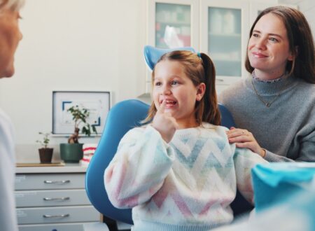 Parent speaking with a childrens orthodontist about family orthodontic care and early orthodontic treatment for their child.