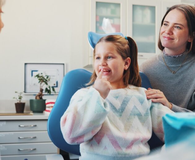 Parent speaking with a childrens orthodontist about family orthodontic care and early orthodontic treatment for their child.