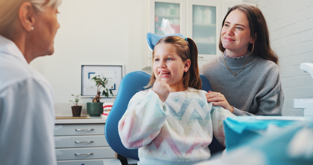 Parent speaking with a childrens orthodontist about family orthodontic care and early orthodontic treatment for their child.