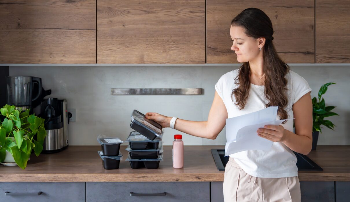 Woman looking at her order from one of the best healthy meal delivery services providers in Australia.